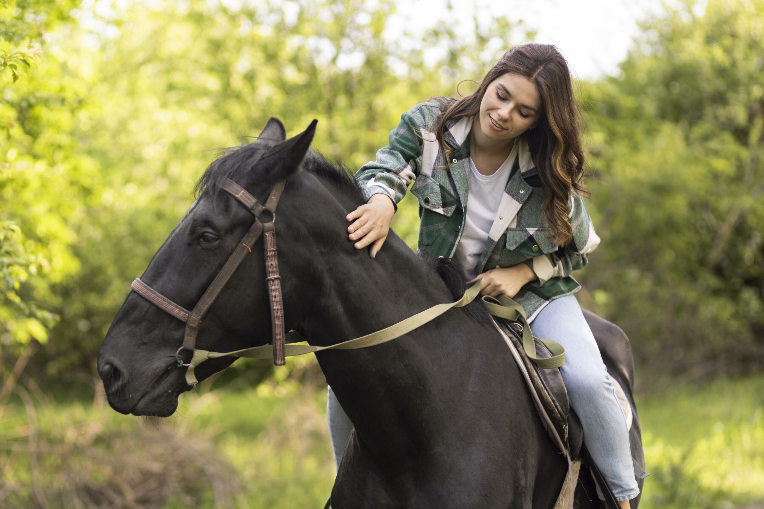 Woman riding and petting a horse.